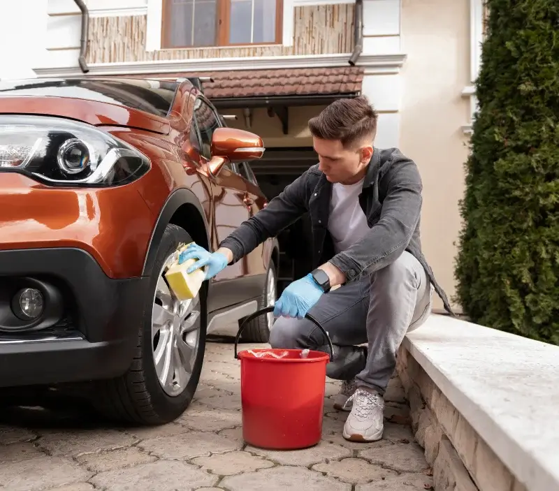 Lavage auto à domicile Quelaines-Saint-Gault : professionnel intervenant sur un véhicule